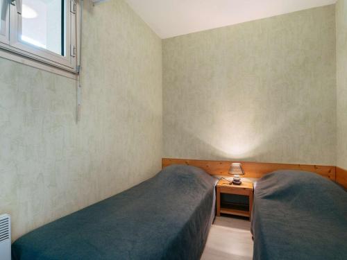 une petite chambre avec deux lits et une fenêtre dans l'établissement Appartement cosy à Carnac, 200m de la plage, terrasse, parking, TV, animaux acceptés, pour 4 personnes - FR-1-477-96, à Carnac