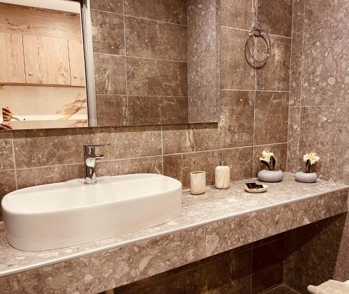 a bathroom with a white sink and a mirror at Peter's Place Studios & Suites in Faliraki