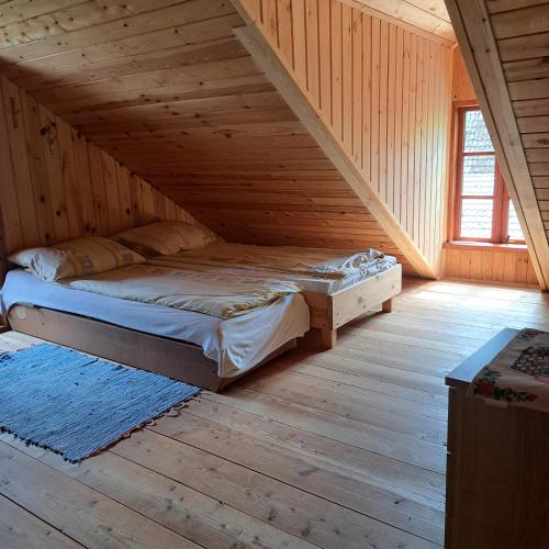 a bedroom with a bed in a wooden attic at Domek Myśliwski z sauną 