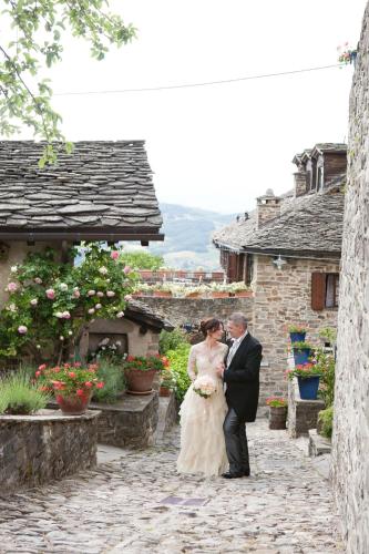 a bride and groom standing in front of a building at Borgo Casale in Albareto