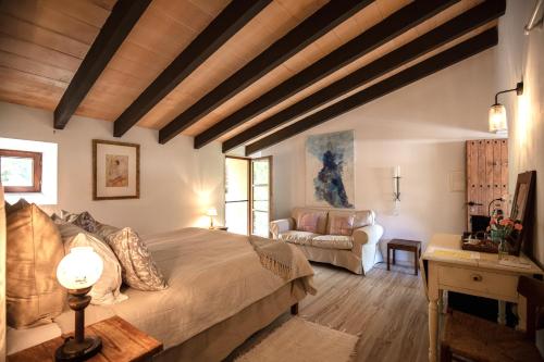 a bedroom with a large bed and a couch at Agroturismo Son Boronat in Calvià