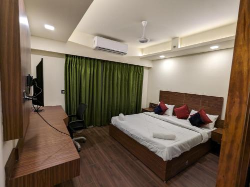 a bedroom with a bed and a green curtain at PLUTO HOMES Dehradun in Dehradun