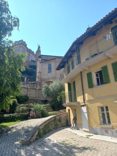 a yellow building with a bench next to a street at Il giardino di Olivia in Guarene
