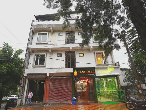 Biały budynek z sklepem przed nim w obiekcie Hotel Rosewood Inn w mieście Rājpur
