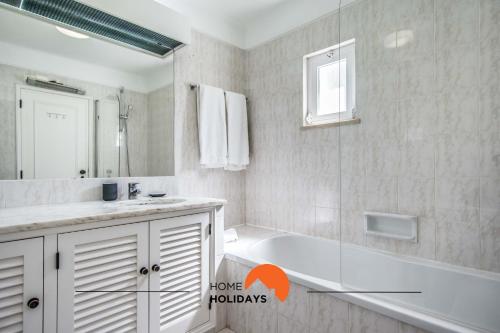 bagno con vasca, lavandino e specchio di #122 Fully Equiped with Pools, Golf Course, Garden ad Albufeira