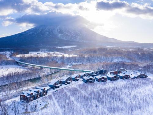 a group of cars parked in front of a snow covered mountain at Panorama Niseko in Kutchan