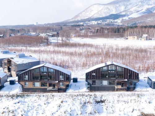 two houses in the snow with mountains in the background at Panorama Niseko in Kutchan