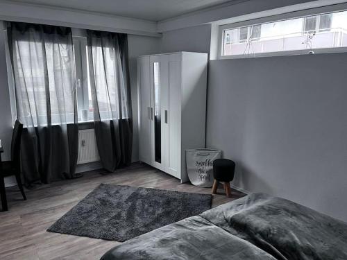 a bedroom with a bed and two large windows at Ferienwohnung am MeetingPoint in Weilmünster