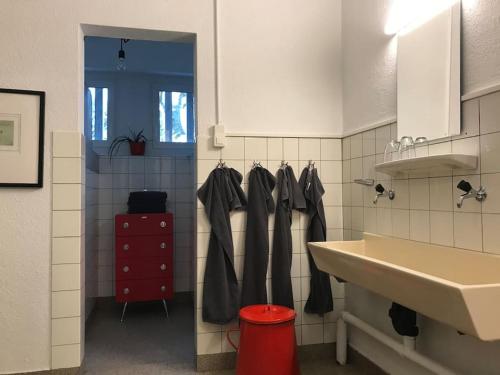 uma casa de banho com um lavatório branco e um armário vermelho em Loft63 am Bodensee em Arbon
