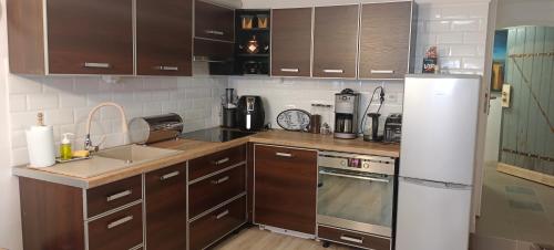 a kitchen with brown cabinets and a white refrigerator at Apartament WILLA ANTA in Dębno