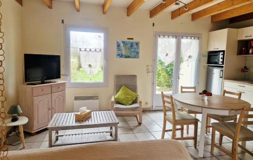sala de estar con mesa y TV en Les Maisons de Kerdavid'île, en Locmaria