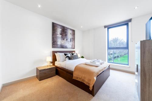 a bedroom with a bed and a large window at Immaculate 3BR apt in Hackney in London