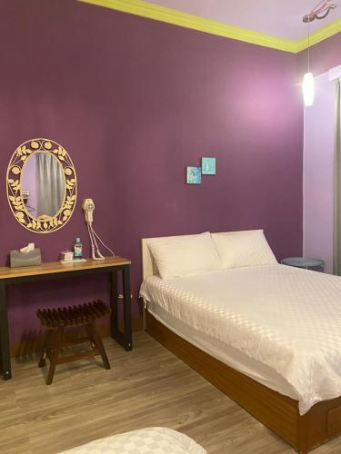 a bedroom with a bed and a table with a mirror at 叁樓民宿 in Taitung City