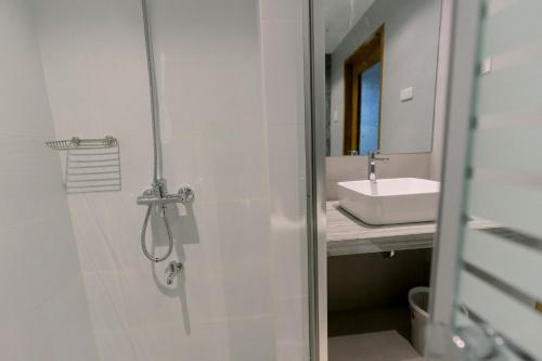 een badkamer met een douche en een wastafel bij Madonna Hometel and Suites New Pandan in Panabo