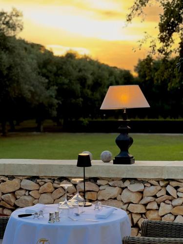 a table with a lamp on top of a stone wall at Villa Di Noi in Arnesano