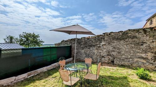 a patio table and chairs with an umbrella at Le Cocon des Hautes-Côtes in Fussey
