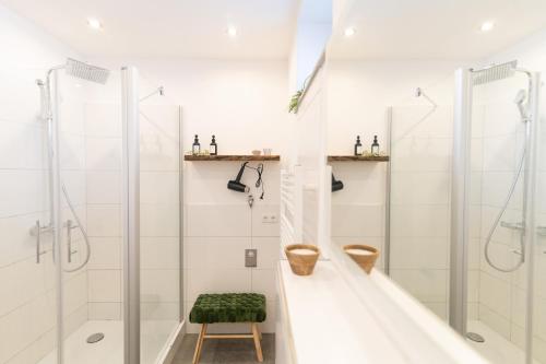 ein weißes Bad mit einer Dusche und einem Stuhl in der Unterkunft Peter Apartments- Apartment mit eigenem Eingang I 30qm I zentrale Lage I Bad I Küche I Terrasse I TV in Fulda