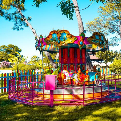 a colorful carousel at a playground in a park at Kimeros Park Holiday Village - Ultra All Inc. Kids Concept in Kemer