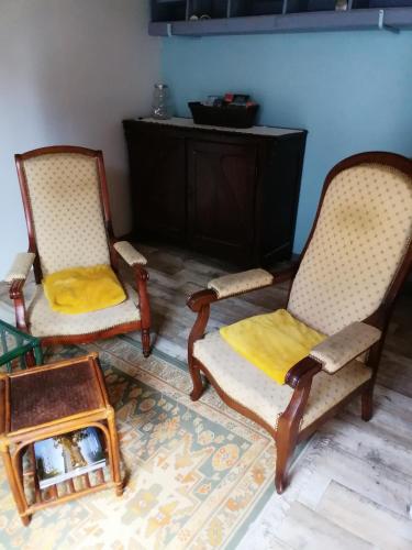 2 sillas y una mesa en la sala de estar en Le petit loft, en La Croix-en-Touraine