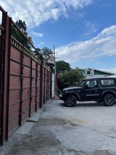 a black truck parked next to a fence at THE GINGKO EYRIE in Kalimpong