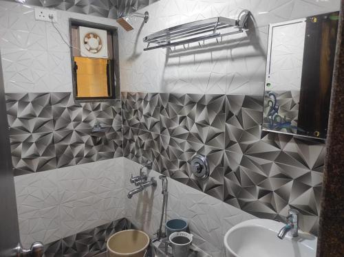 a bathroom with a sink and a mirror at Hotel Deepak Executive, Ganpatipule in Ganpatipule