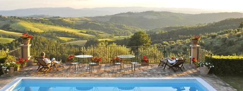 a patio with tables and chairs with a view of the mountains at La Ghirlanda Wine Resort in Saragano