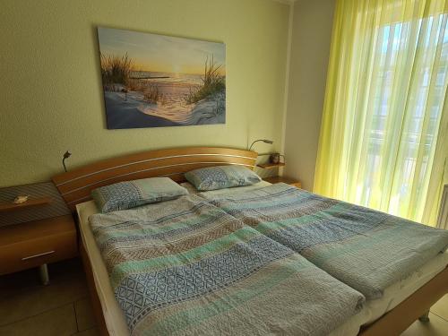 Schlafzimmer mit einem Bett und einem Fenster in der Unterkunft Ferienwohnung T24 in Graal-Müritz