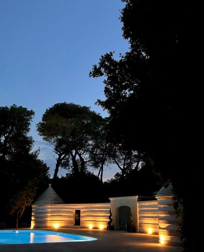 a house with lights around a swimming pool at night at Villa Di Noi in Arnesano
