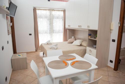 a room with a bed and a white table and chairs at Zagara Holiday House in Siculiana