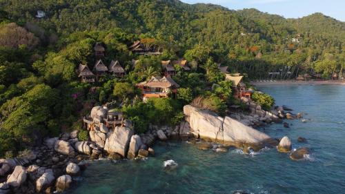 an island in a body of water with houses at Koh Tao Cabana in Koh Tao