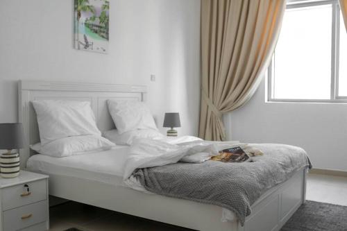 um quarto branco com uma cama e uma janela em BEST APARTMENT 2 Bedroom Beach Front (City View) em Abu Dhabi