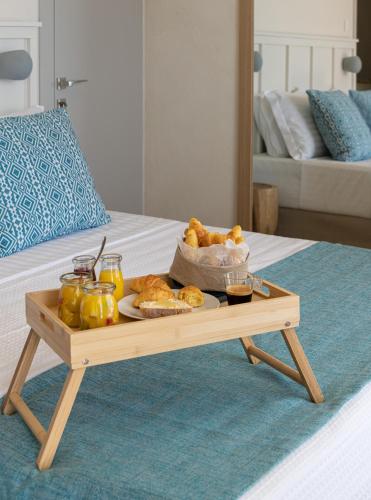 a tray of food on a table on a bed at Etesians Suites & Villas in Super Paradise Beach