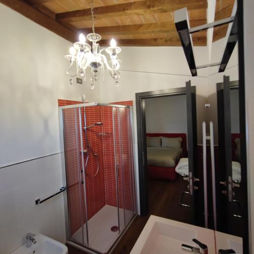 a bathroom with a shower and a sink and a chandelier at Villa Giulia Fashion B&B in Strada