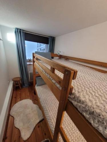 une chambre avec deux lits superposés et une fenêtre dans l'établissement Appartement cosy - grande terrasse pleine vue lac, à Gérardmer