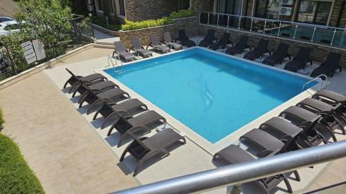 a large swimming pool with chairs and a swimming pool at Horizont Apartment Sozopol in Sozopol