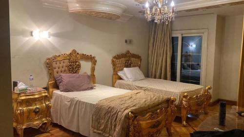 sypialnia z 2 łóżkami i żyrandolem w obiekcie شقة فخمة علي كورنيش النيل - المعادي w Kairze