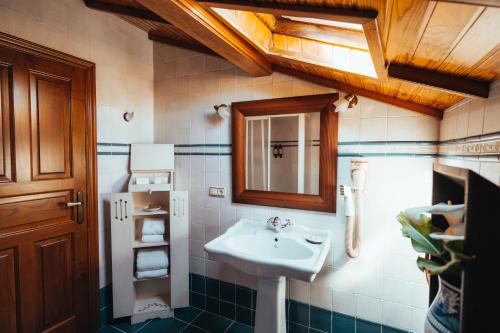 W łazience znajduje się umywalka i lustro. w obiekcie Os Migueliños w mieście Catoira