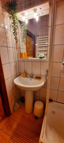 a bathroom with a sink and a mirror and a tub at Yellow House Mamaia Nord in Mamaia Sat/Năvodari