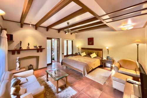 a bedroom with a bed and a living room at Ramsukh Resorts and Spa in Mahabaleshwar