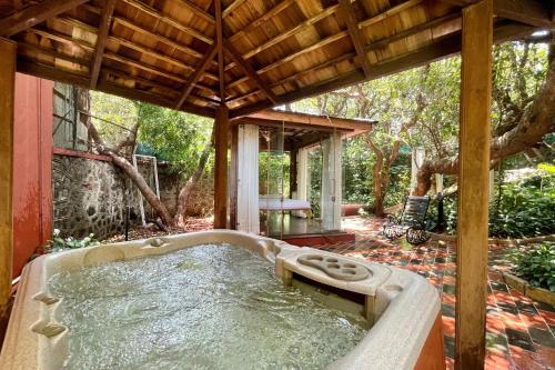 a hot tub in a backyard with a wooden roof at Ramsukh Resorts and Spa in Mahabaleshwar