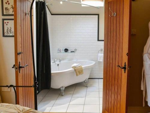 a bathroom with a bath tub in a room at The Old Telephone Exchange - surrounded by fields! in Harrogate