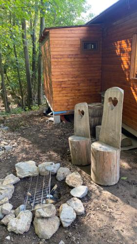 einen Hinterhof mit einer Feuerstelle und Holzscheiten und einer Hütte in der Unterkunft Chatka pod lesom in Banská Štiavnica
