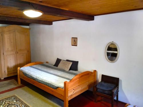 a bedroom with a wooden bed and a chair at Penzion U kozy in Chřibská