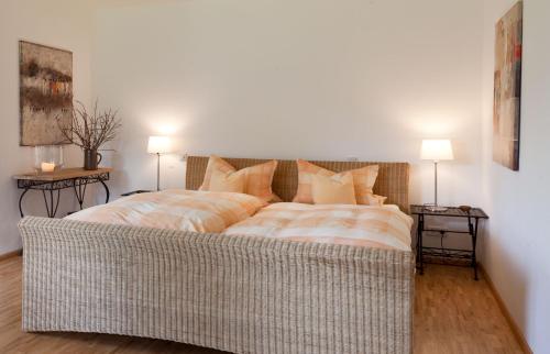 a large bed in a room with two end tables at Idyll am Weinberg in Rhodt unter Rietburg