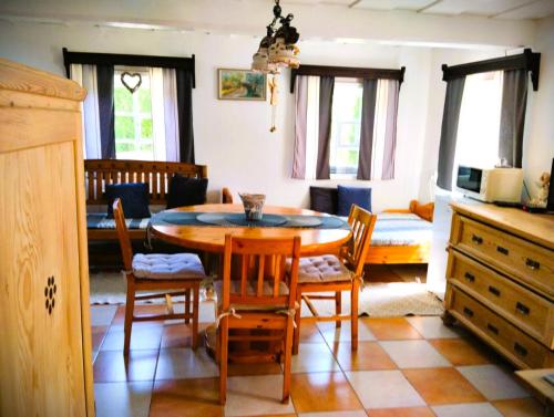 a kitchen and dining room with a table and chairs at Penzion U kozy in Chřibská