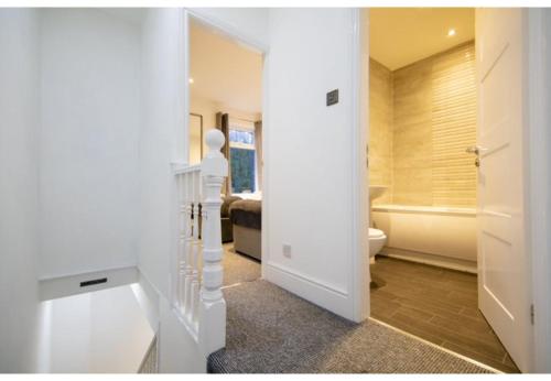 Habitación con baño con bañera y aseo. en Stunning Bolton abode – Pool table – Parking en Bolton