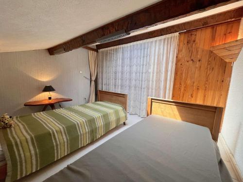 une chambre d'hôtel avec deux lits et une fenêtre dans l'établissement Appartement 2 pièces avec mezzanine, terrasse et parking, à 500m de la plage - Fréjus - FR-1-226A-42, à Fréjus