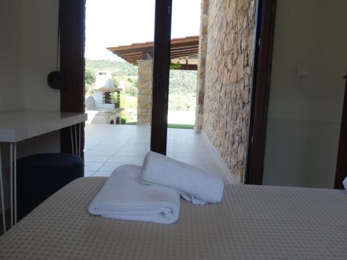 a bed with towels sitting on top of it at Blue Dream Villa in Nea Skioni