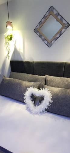 a white wreath on a bed in a room at L'Essentiel - Love 5 Etoiles in Talmont