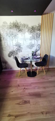 a dining room with a table and two chairs at L'Essentiel - Love 5 Etoiles in Talmont